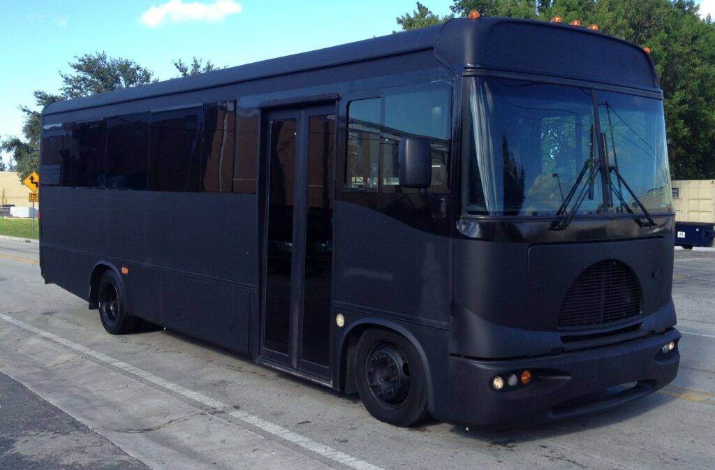a large black party bus parked in miami.