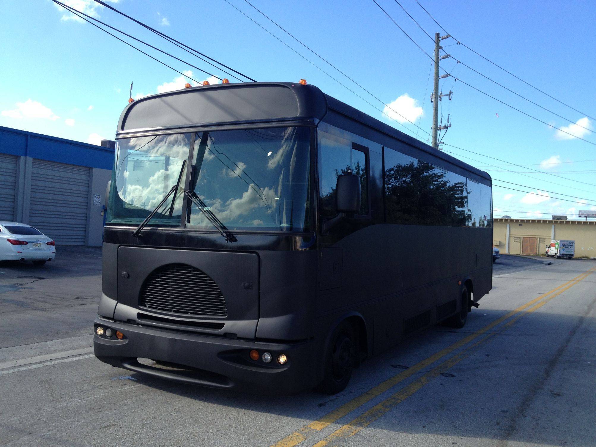 a black bus parked in a parking lot.