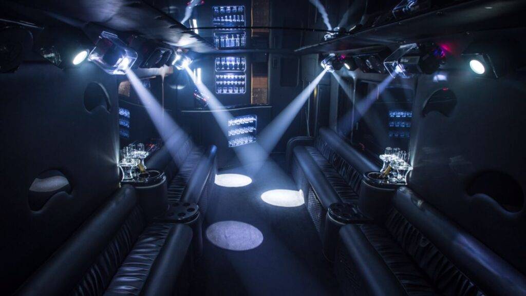 a dimly lit party bus with several spotlights on the ceiling.